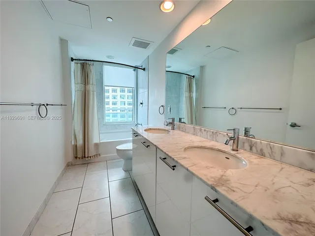a bathroom with a granite countertop sink mirror and shower