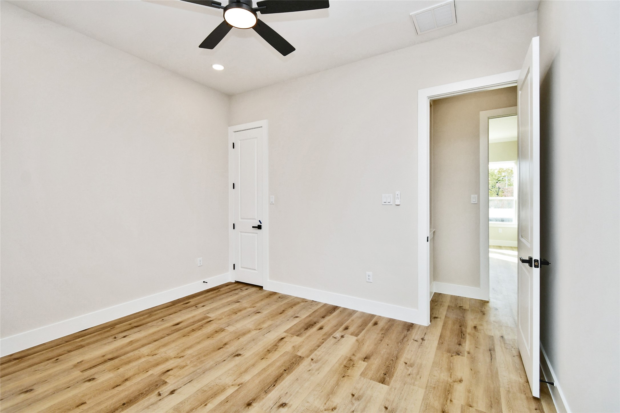 3231 Tuam Street Houston, TX 77004 - Photo 37 of 49 an empty room with wooden floor a ceiling fan and staircase