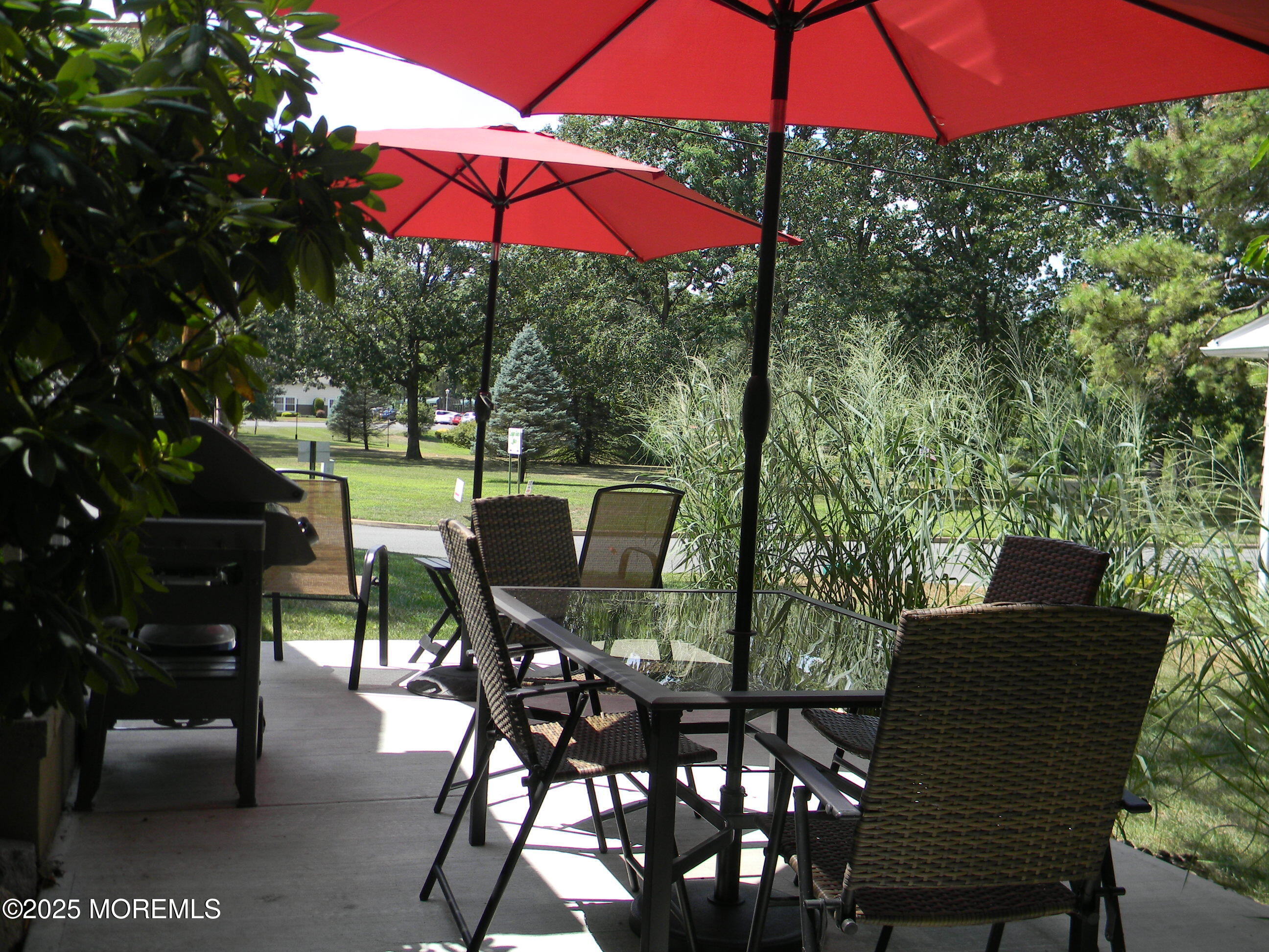 7 B Roosevelt City Road, Unit B Whiting, NJ 08759 - Photo 30 of 48 a view of a patio with table and chairs under an umbrella