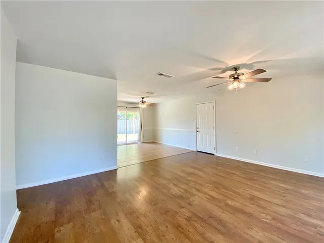 a view of a livingroom with a ceiling fan and wooden floor