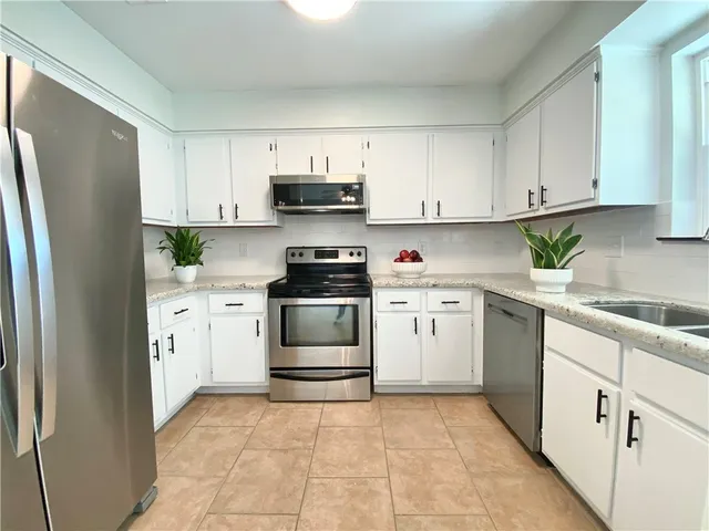 a kitchen with white cabinets and white appliances