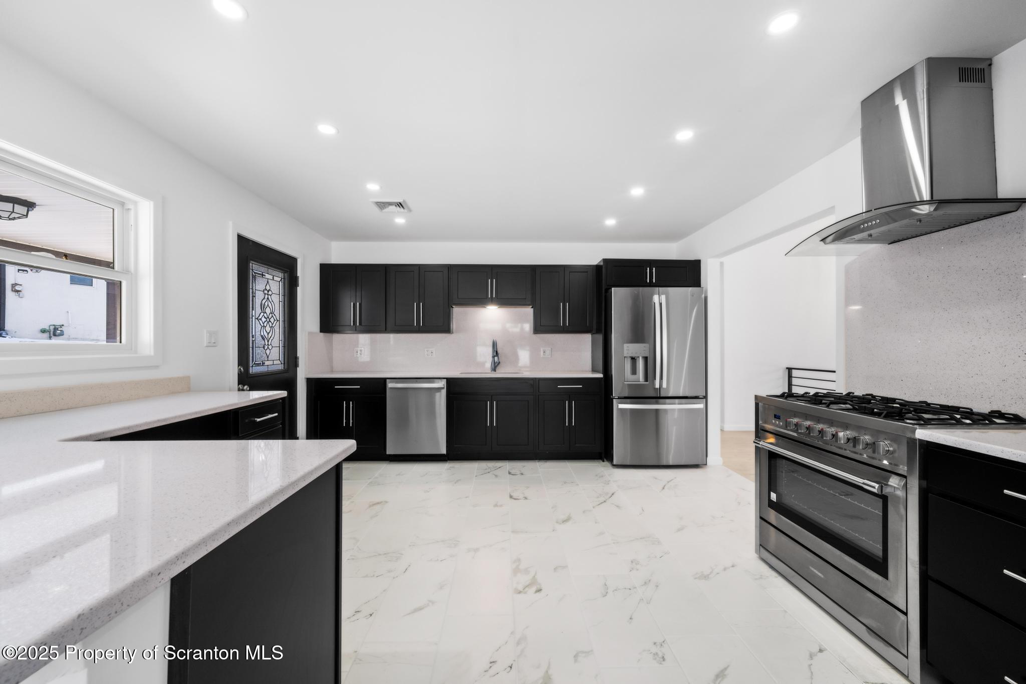80 Elmhurst Boulevard Scranton, PA 18505 - Photo 12 of 56 a kitchen with stainless steel appliances kitchen island granite countertop a stove and a refrigerator