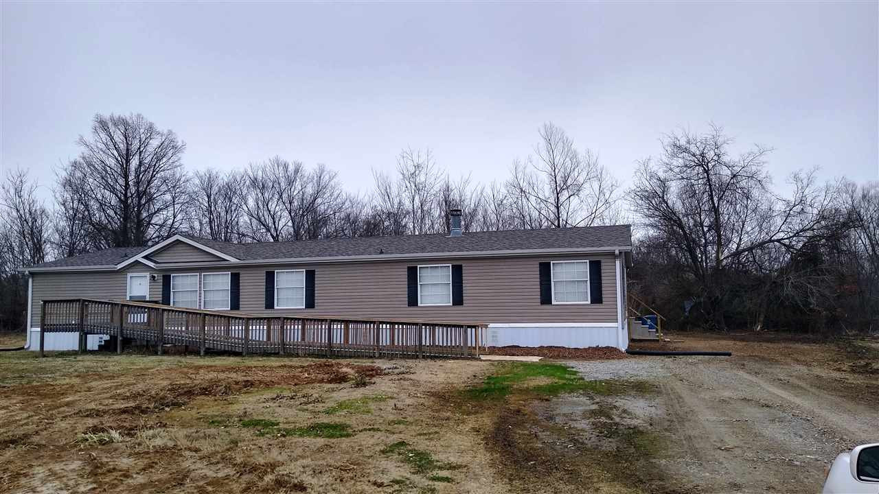 a front view of a house with yard and trees