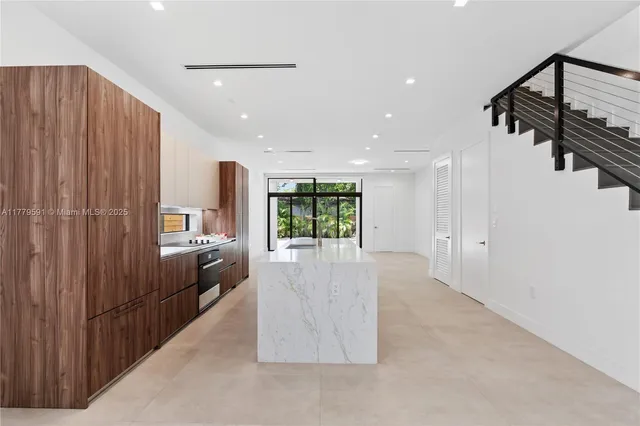 a kitchen with kitchen island stainless steel appliances a sink stove and cabinets
