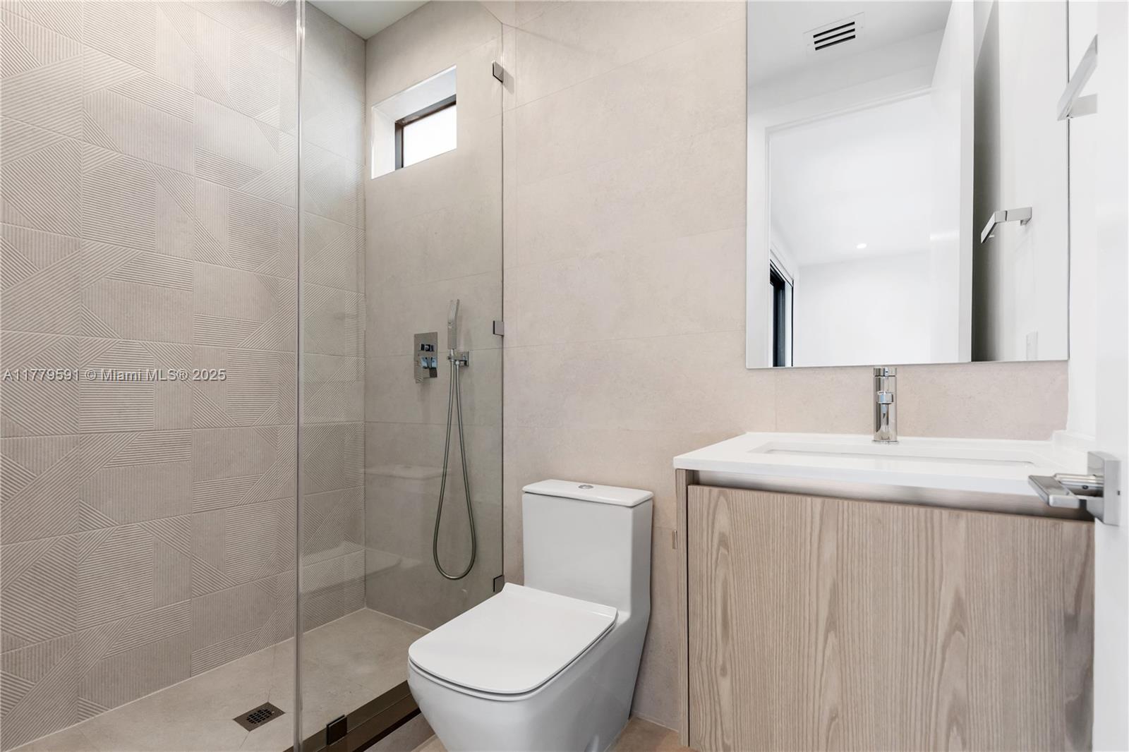 3045 Elizabeth Street, Unit 3045 Miami, FL 33133 - Photo 45 of 72 a bathroom with a granite countertop toilet a sink a mirror and shower