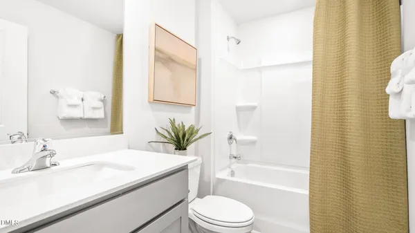 a bathroom with a granite countertop sink a toilet a mirror and shower