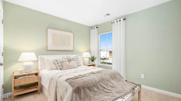 a bedroom with a bed and a lamp