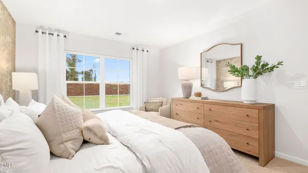 a bedroom with a large bed and a potted plant