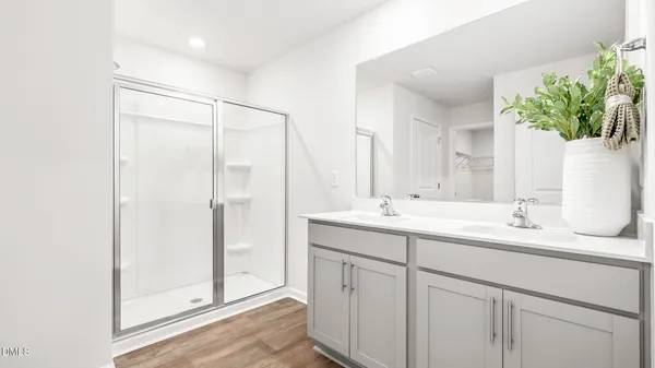 a bathroom with a double vanity sink mirror and shower