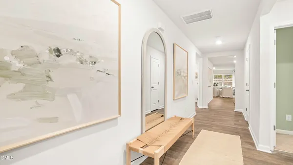 a view of a hallway with wooden floor and a living room