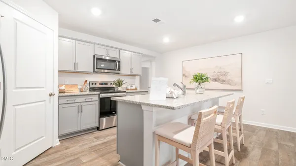 a kitchen with granite countertop white cabinets and stainless steel appliances