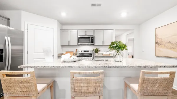 a kitchen with granite countertop a sink a counter top space and stainless steel appliances