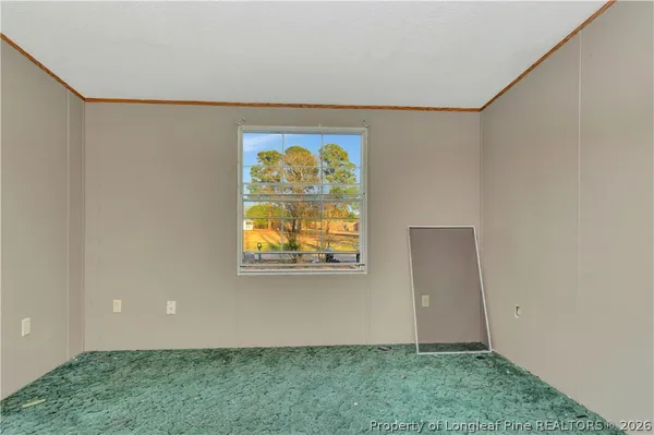 a view of an empty room with closet and a bathroom