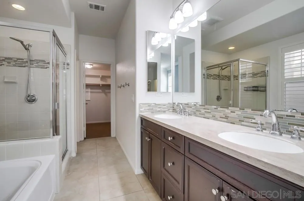1859 Khaki Lane Chula Vista, CA 91913 - Photo 19 of 62 a bathroom with a granite countertop double vanity sink mirror and shower