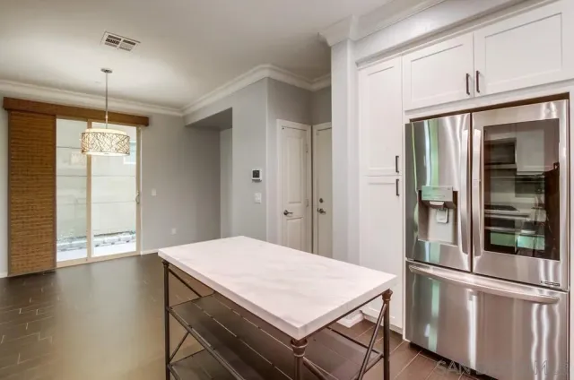a kitchen with a refrigerator a stove and a wooden floor