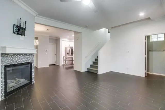 a view of an empty room with wooden floor and a fire place