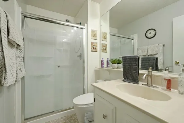 a bathroom with a sink a toilet and shower