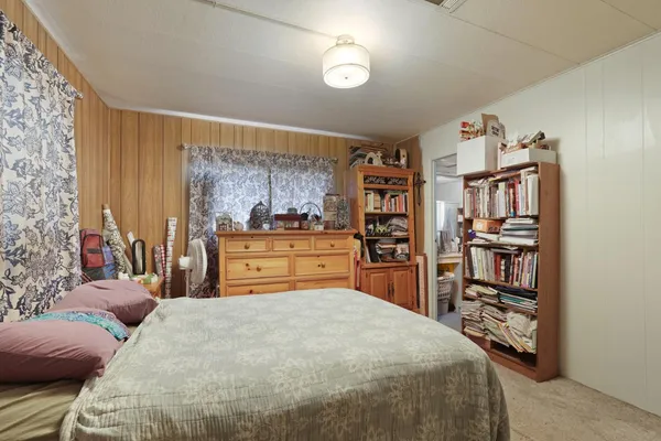 a bedroom with a large bed and a book shelf