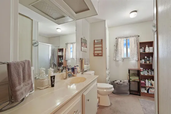a bathroom with a double vanity sink toilet and shower