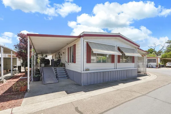 a view of house with a large tree and wooden fence