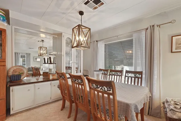a view of dining room and livingroom with furniture wooden floor a chandelier