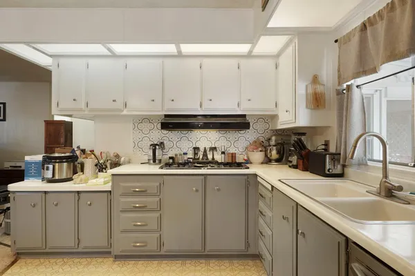 a kitchen with cabinets appliances a sink and a counter top space