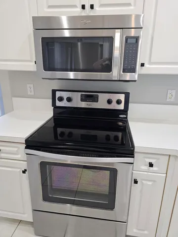 a stove top oven sitting inside of a kitchen with stainless steel appliances
