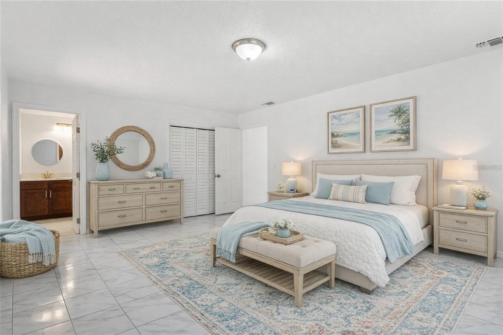 10237 Carrin Road Spring Hill, FL 34608 - Photo 15 of 39 a bedroom with a bed a mirror and a table