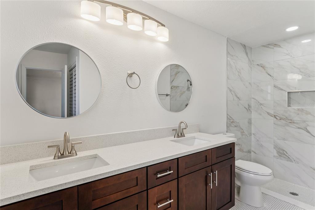 10237 Carrin Road Spring Hill, FL 34608 - Photo 18 of 39 a bathroom with a double vanity sink and a mirror