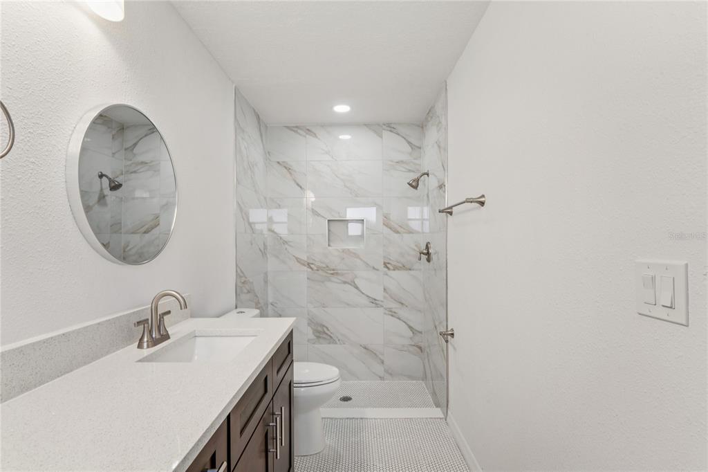 10237 Carrin Road Spring Hill, FL 34608 - Photo 19 of 39 a bathroom with a sink a toilet and a mirror