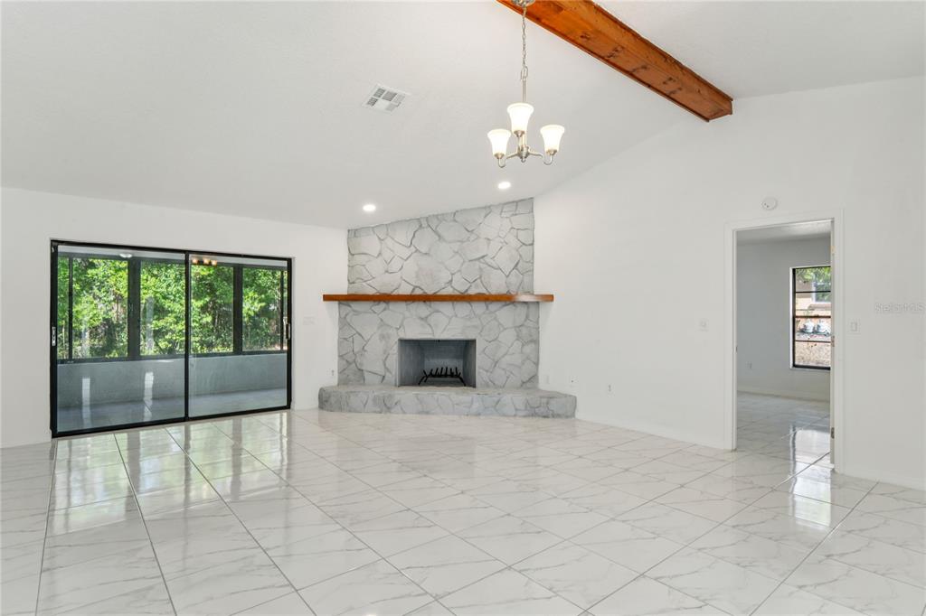 10237 Carrin Road Spring Hill, FL 34608 - Photo 5 of 39 an empty room with fan and a fireplace
