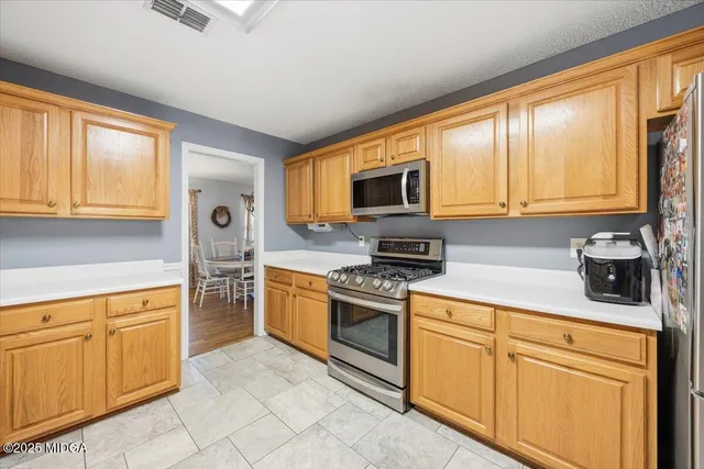 a kitchen with cabinets stainless steel appliances and sink