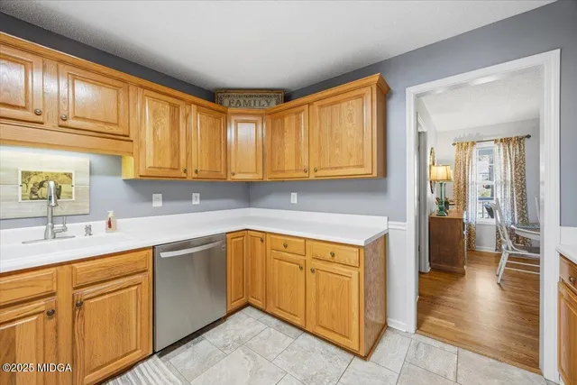 a kitchen with stainless steel appliances granite countertop a sink dishwasher stove and cabinets