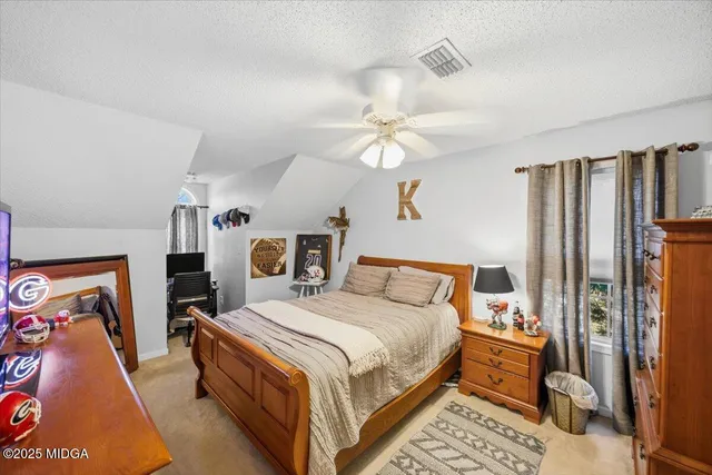 a bedroom with a large bed and a chandelier