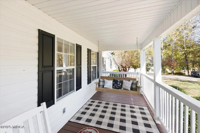 a bedroom with a bed and a large window with balcony view