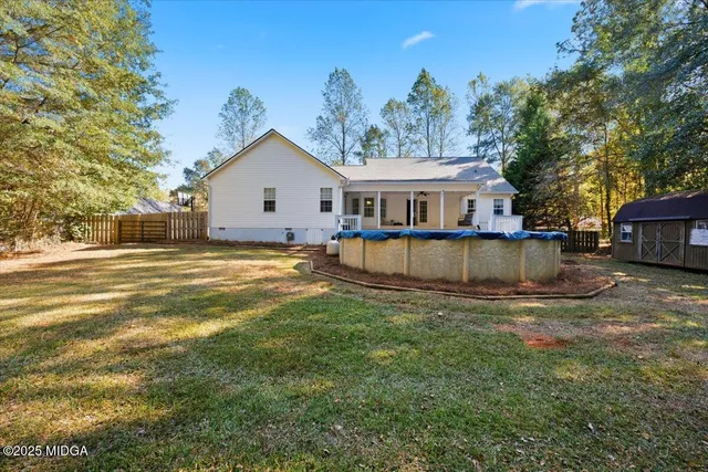 a view of a house with a big yard and large trees