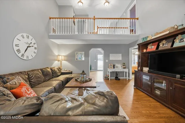 a living room with furniture a large window and a flat screen tv