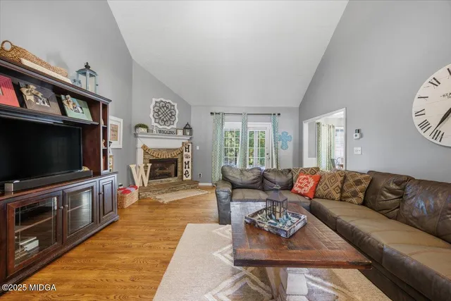 a living room with furniture a flat screen tv and a fireplace