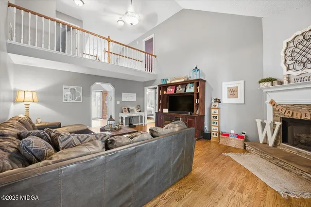 a living room with furniture a flat screen tv and a fireplace
