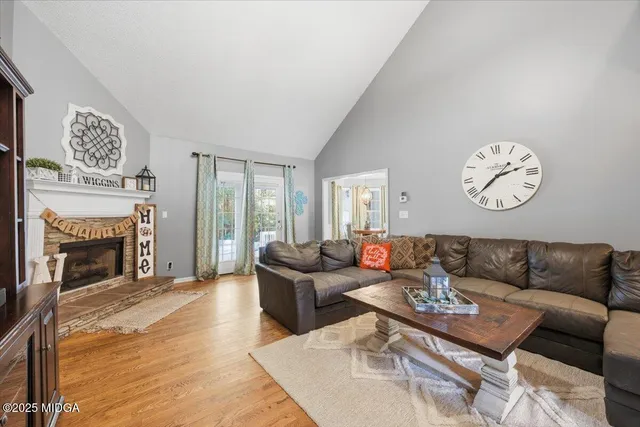 a living room with furniture a fireplace and a large window