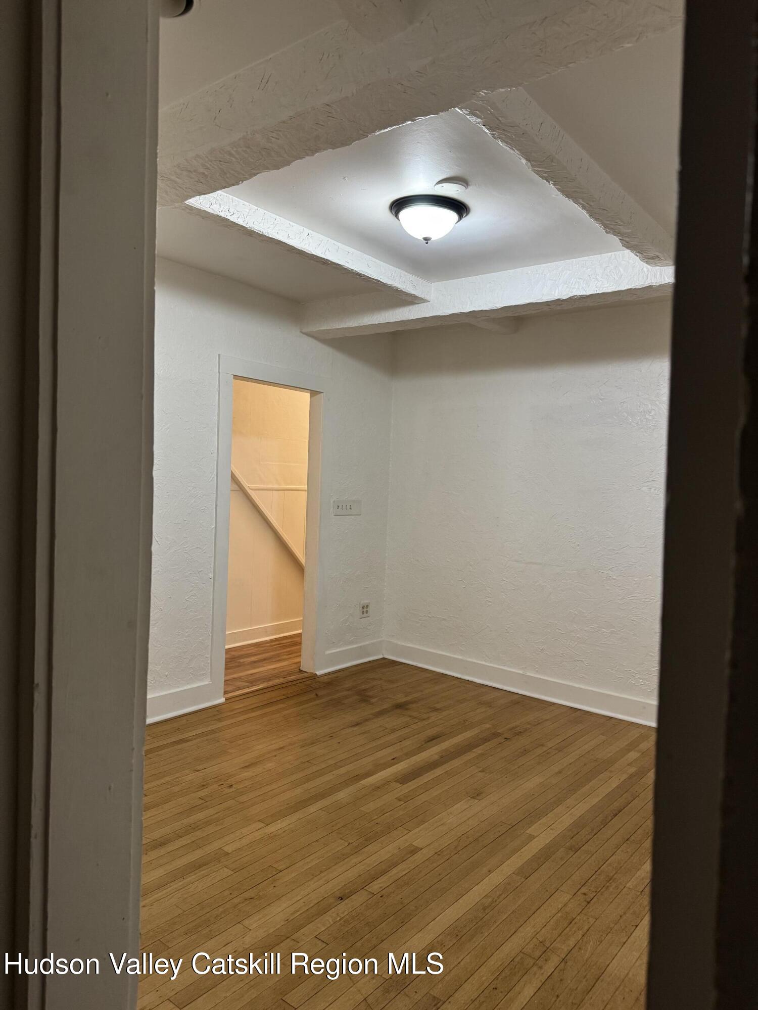 353 Main Street, Unit 2 Cairo, NY 12413 - Photo 11 of 12 an empty room with wooden floor and windows