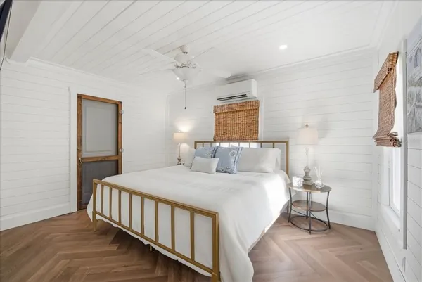 a bedroom with a bed tv and a window