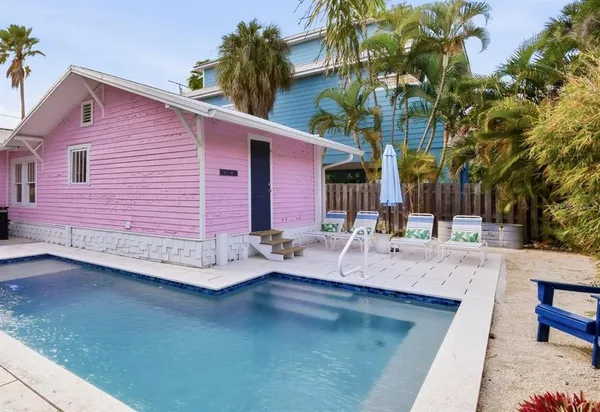 a view of a backyard with swimming pool and sitting area