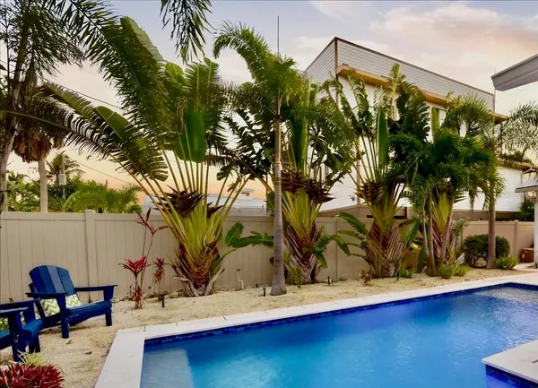 a view of backyard with swimming pool and furniture