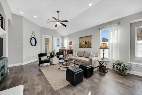 a living room with furniture wooden floor and a large window