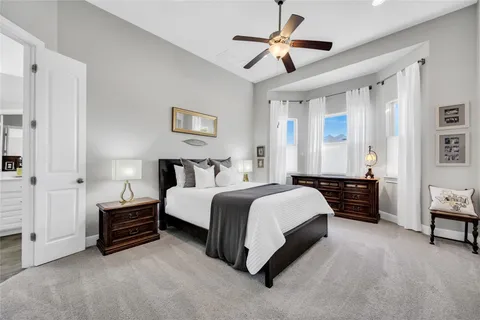 a spacious bedroom with a bed and a chandelier