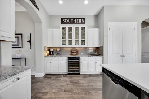 a kitchen with granite countertop white cabinets and appliances