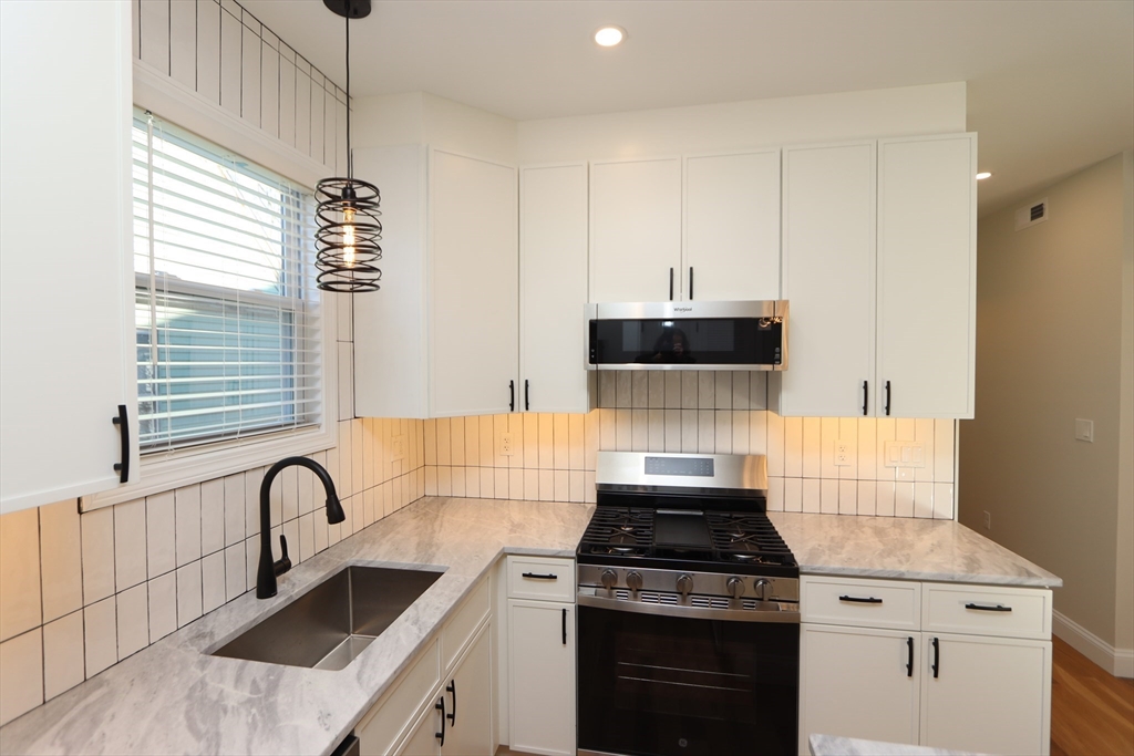 14-16 Harriet Street, Unit 1 Boston, MA 02135 - Photo 1 of 28 a kitchen with granite countertop a stove and a sink