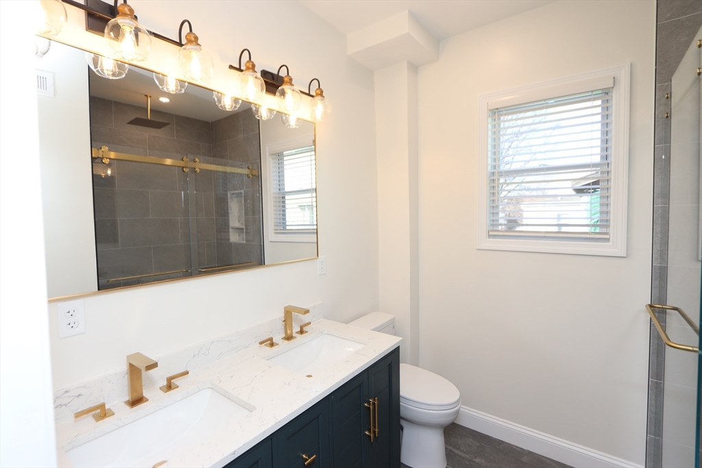 14-16 Harriet Street, Unit 1 Boston, MA 02135 - Photo 15 of 28 a bathroom with a sink vanity mirror and toilet