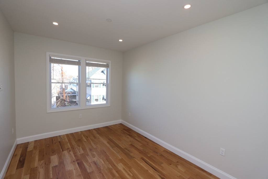 14-16 Harriet Street, Unit 1 Boston, MA 02135 - Photo 18 of 28 an empty room with wooden floor and windows